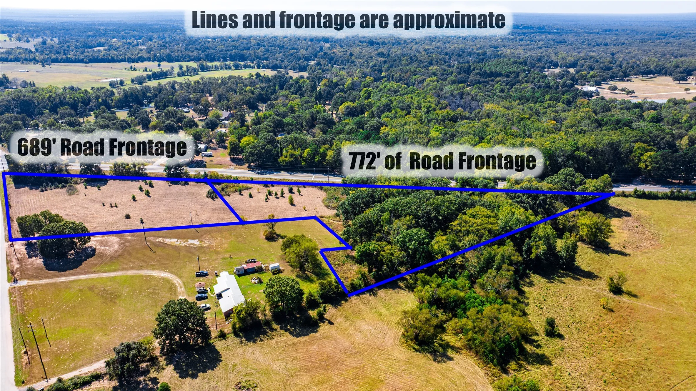 Aerial view of property's location with property parcel outlined and a heavily wooded area