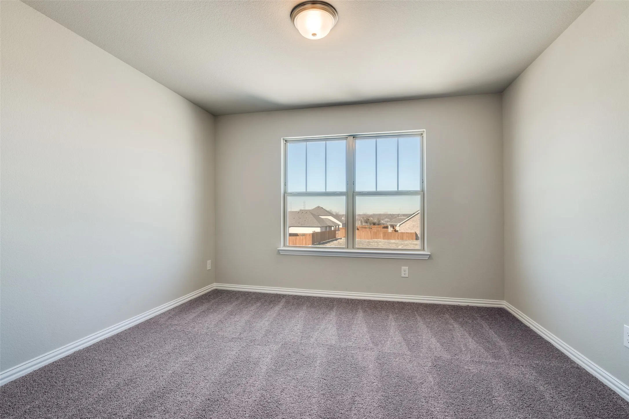 Carpeted empty room featuring baseboards