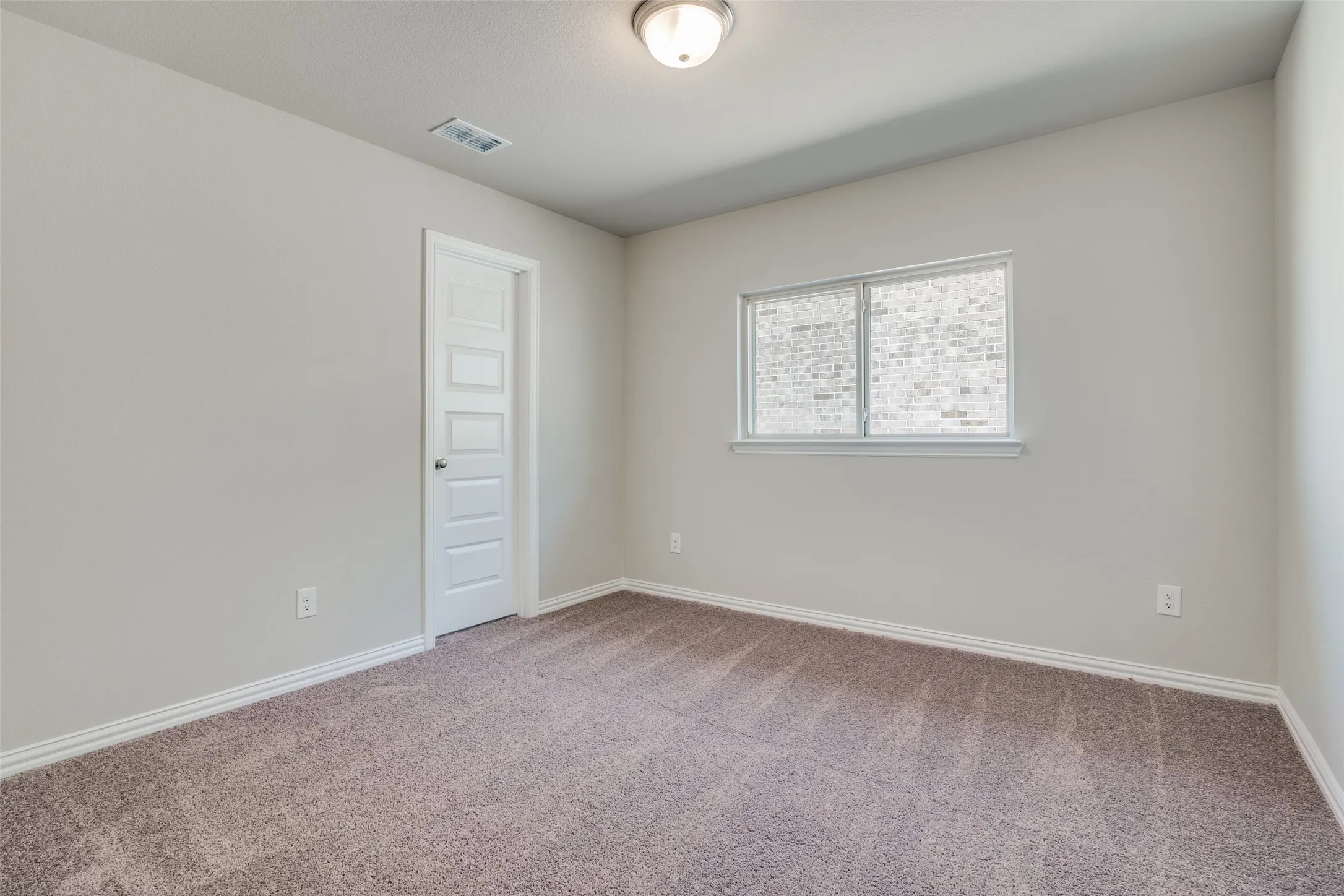 Spare room featuring baseboards and carpet floors