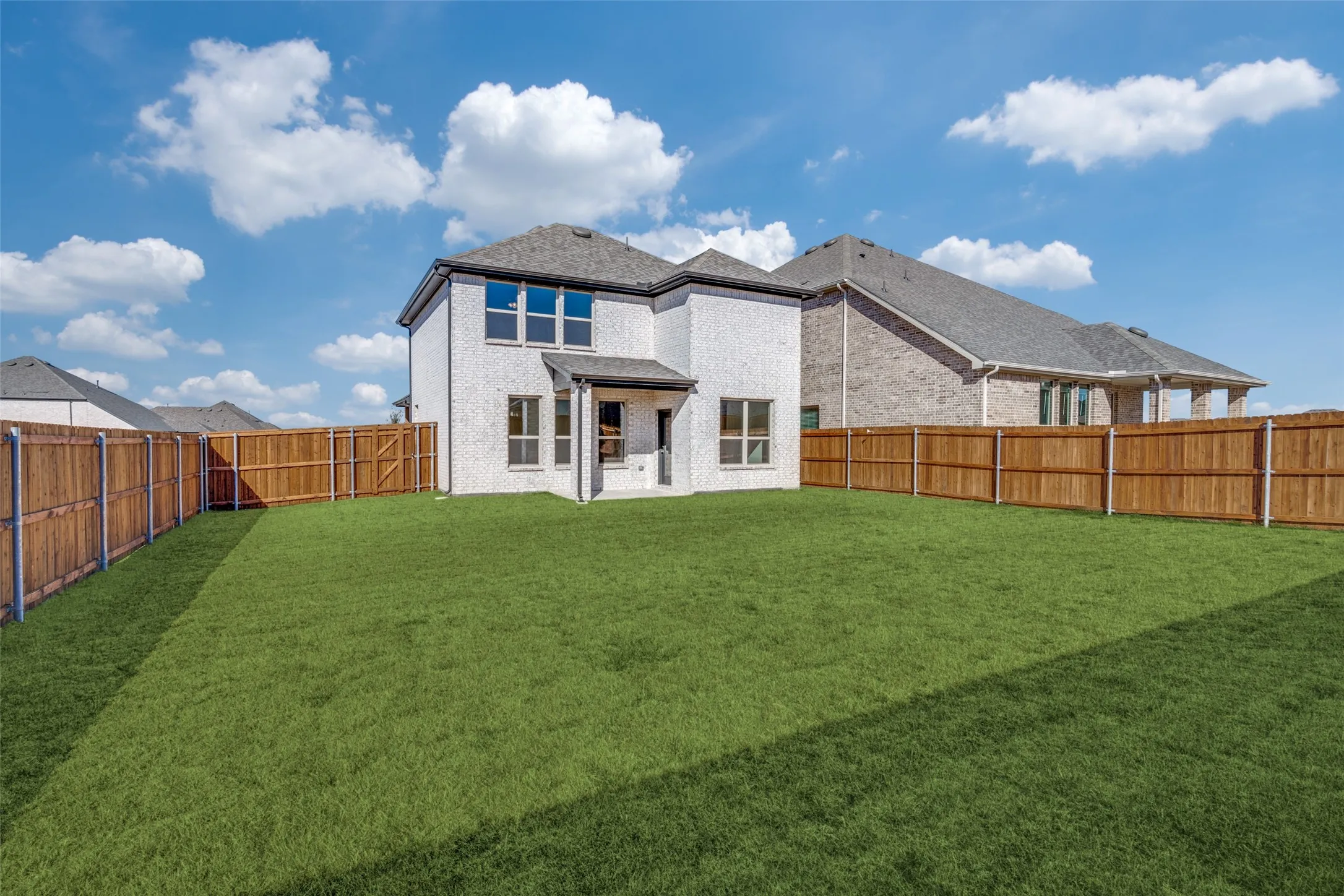 Rear view of property with a patio, brick siding, and a fenced backyard