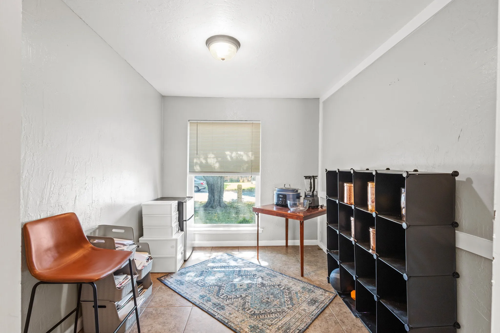 Sitting room featuring light tile patterned floors  and baseboards. Great Huge pantry space next to kitchen