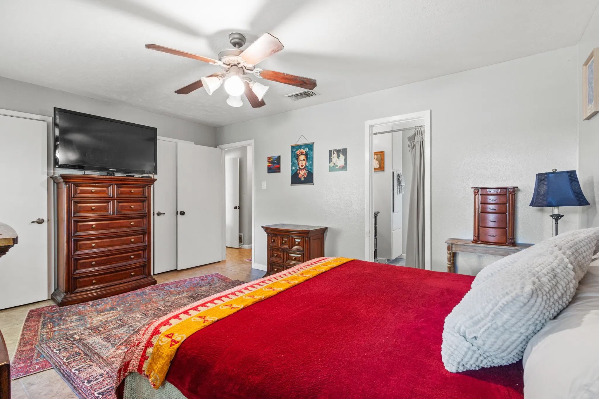Bedroom featuring a ceiling fan, light tile patterned floors, and a closet