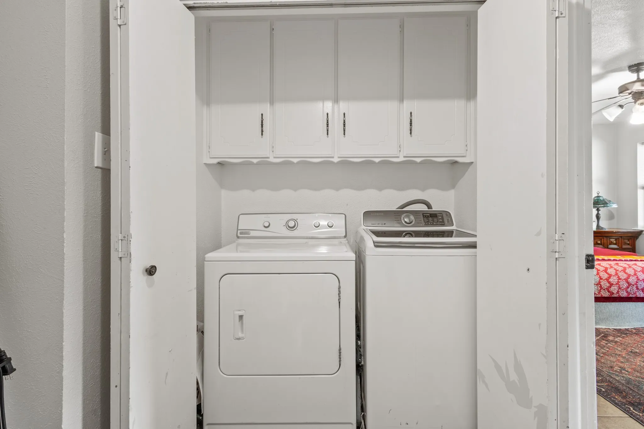 Laundry area featuring cabinet space, independent washer and dryer, and ceiling fan