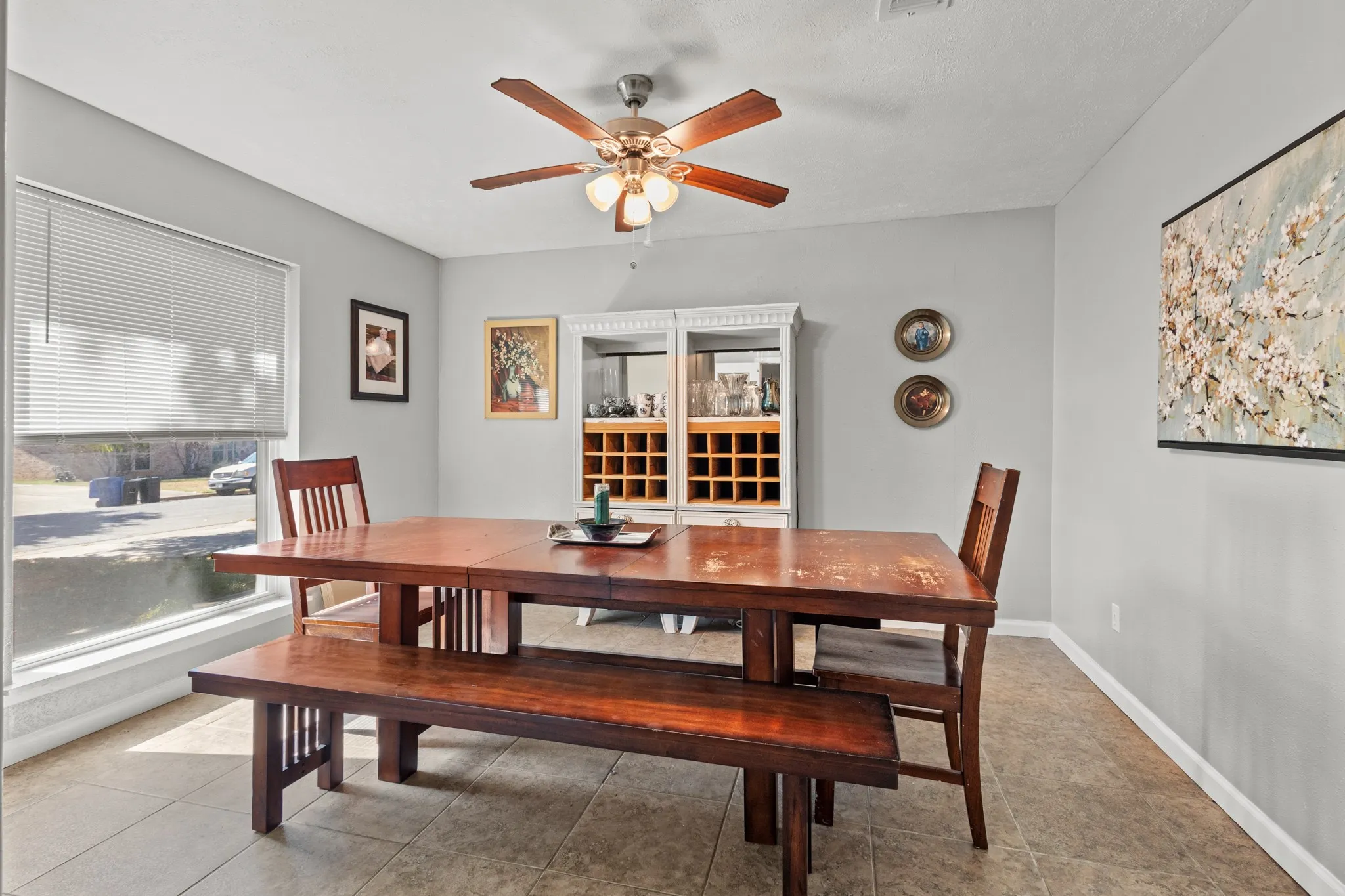 Tiled dining space featuring healthy amount of natural light and ceiling fan