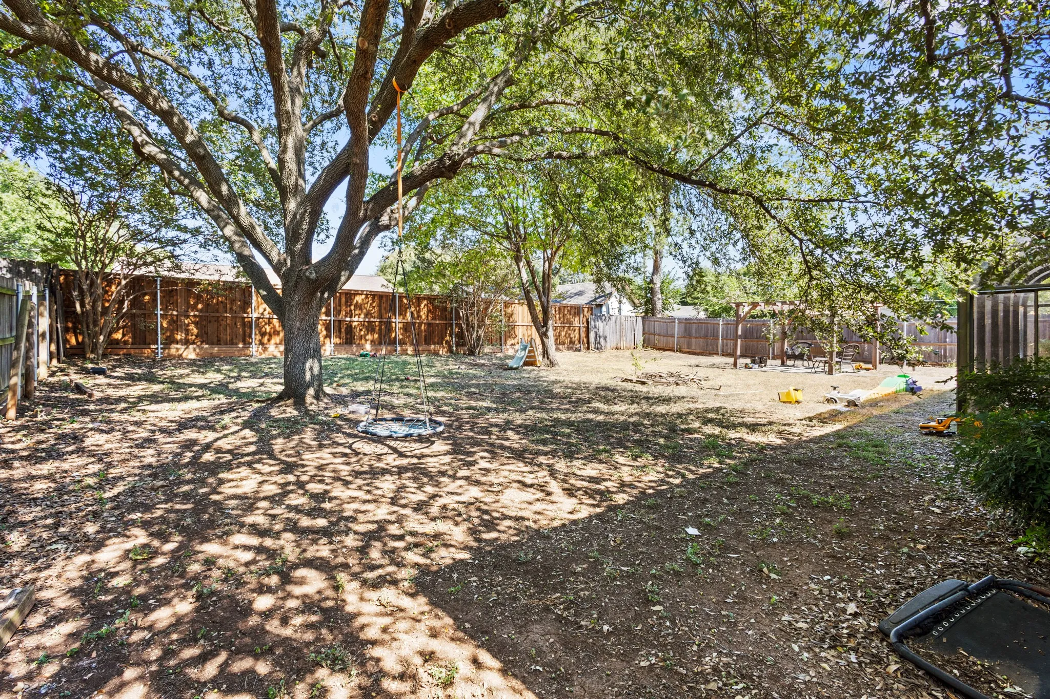 Fenced backyard featuring a playground