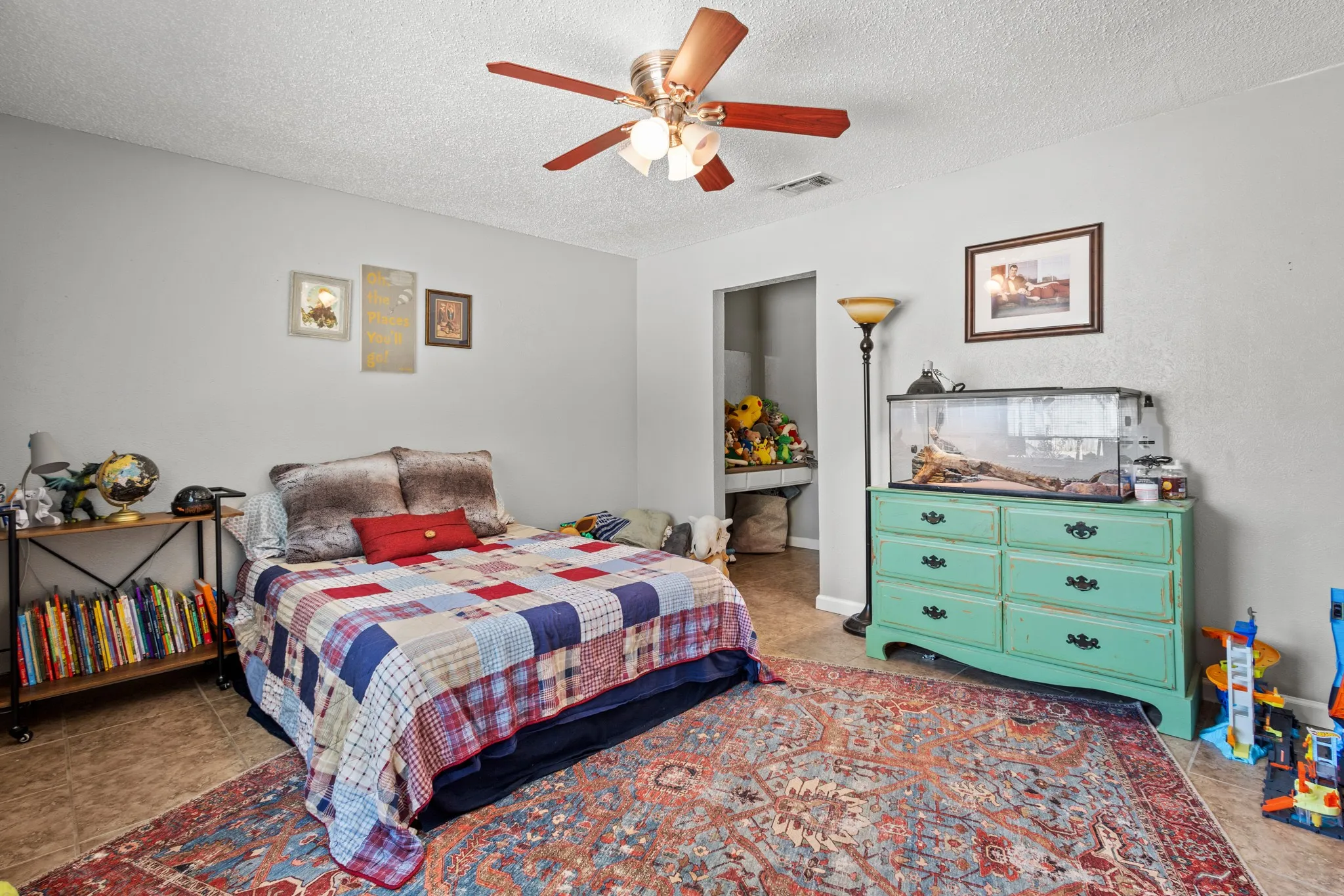 Tiled bedroom with a textured ceiling and a ceiling fan