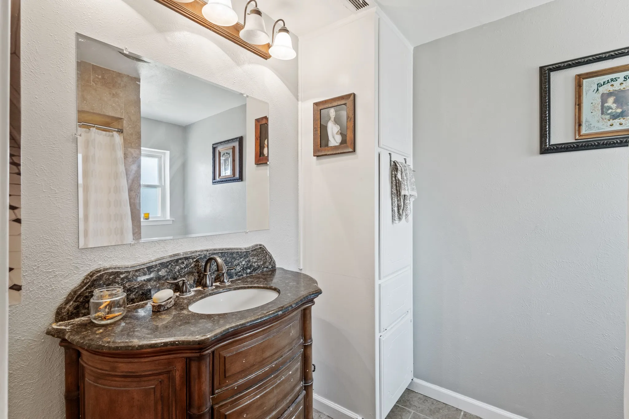 Bathroom with vanity, a textured wall, and curtained shower