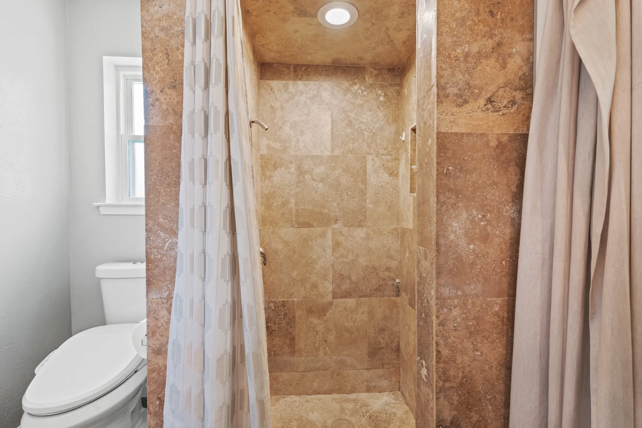 Full bath featuring toilet and a shower stall