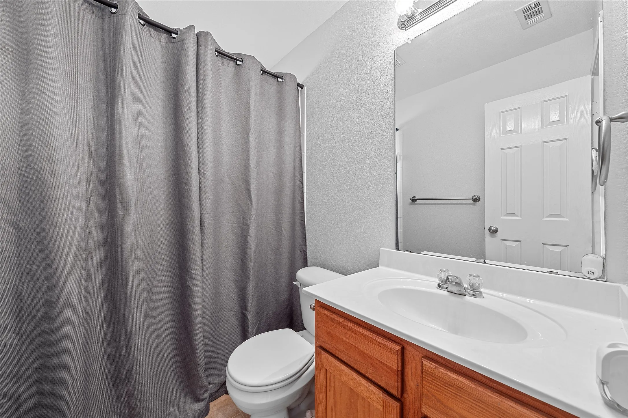Bathroom with vanity and a textured wall