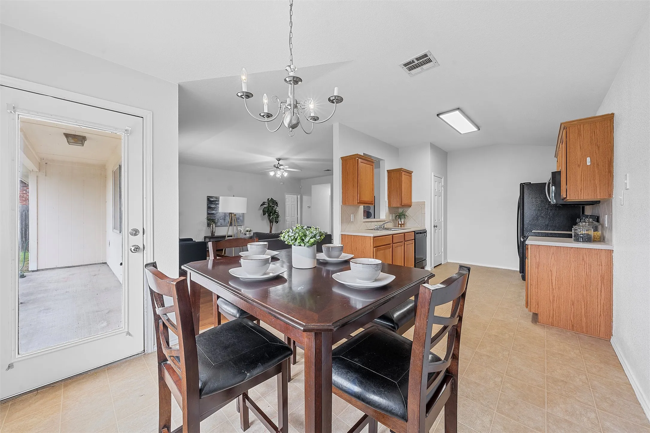 Dining space with a chandelier, light tile patterned floors, and ceiling fan