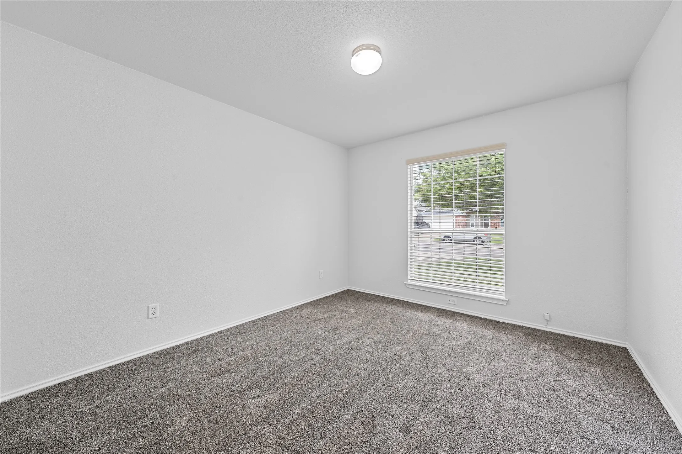 Empty room featuring carpet flooring and baseboards