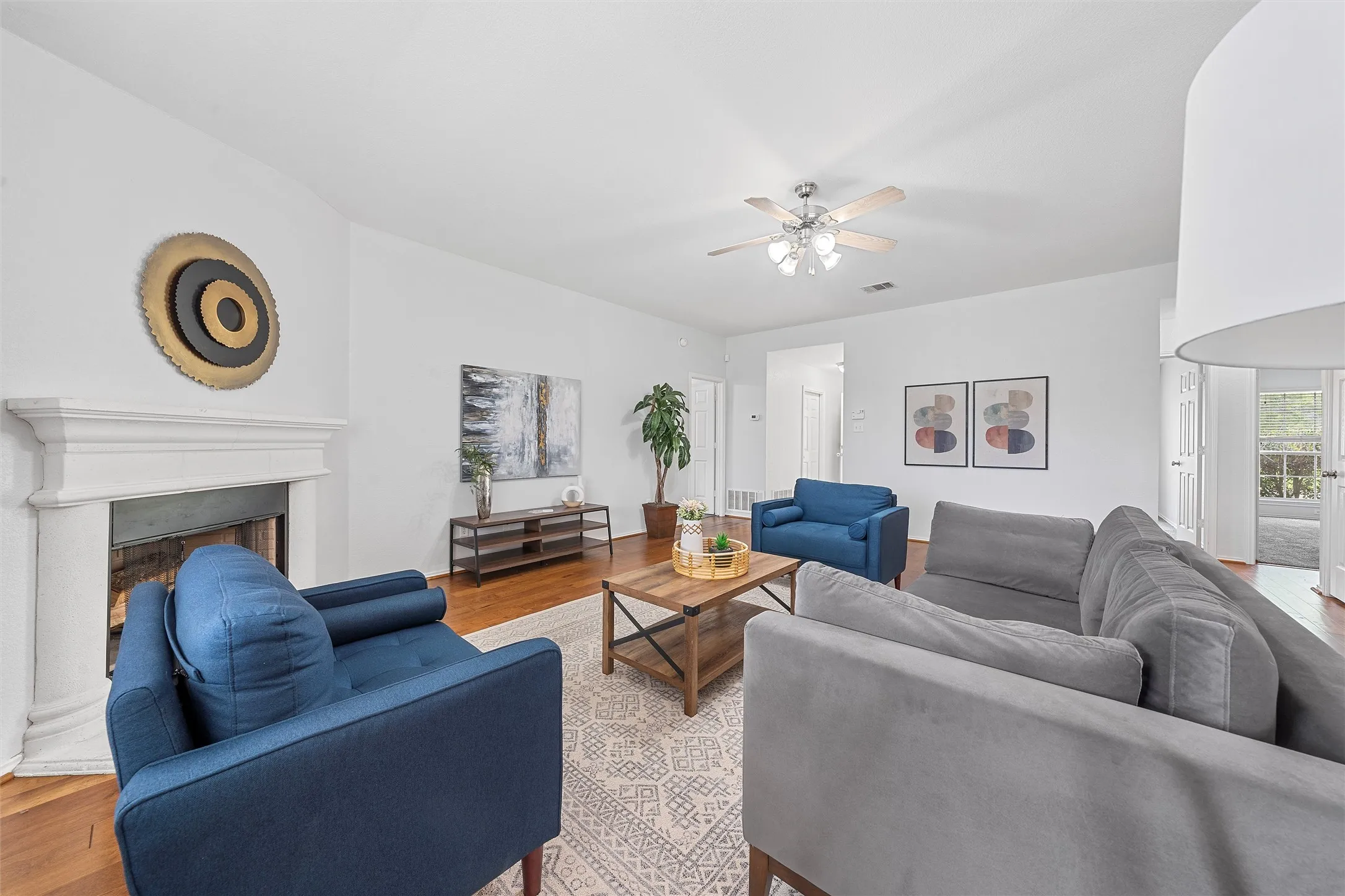 Living area featuring wood finished floors, a fireplace, and ceiling fan