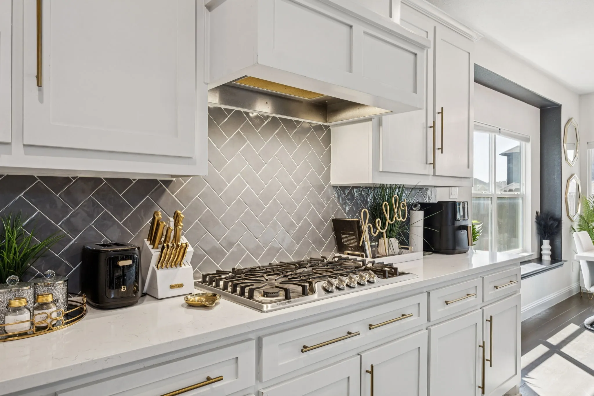 Kitchen featuring white cabinetry, light stone counters, premium range hood, and tasteful backsplash