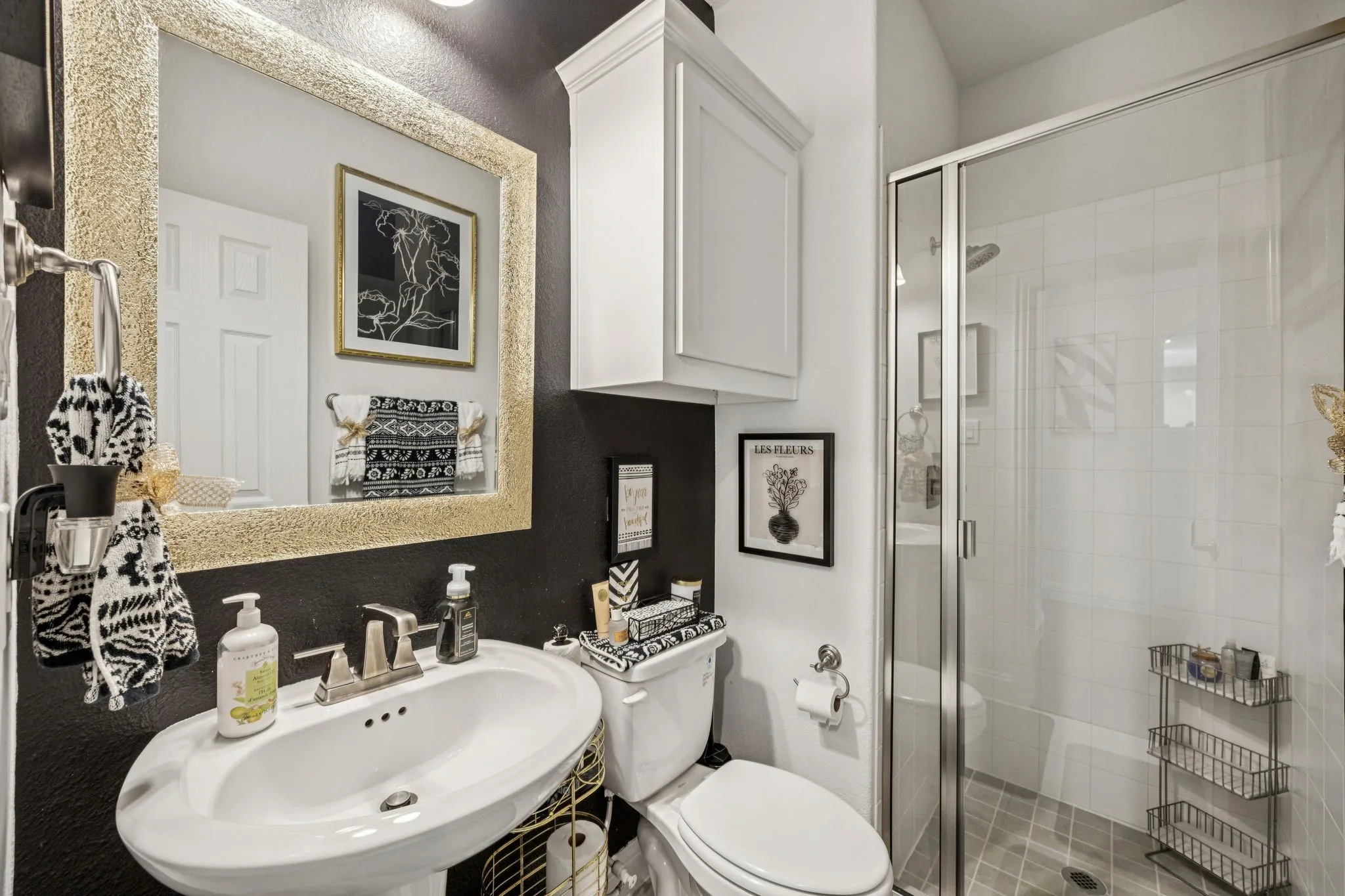 Full bathroom with a textured wall and a stall shower