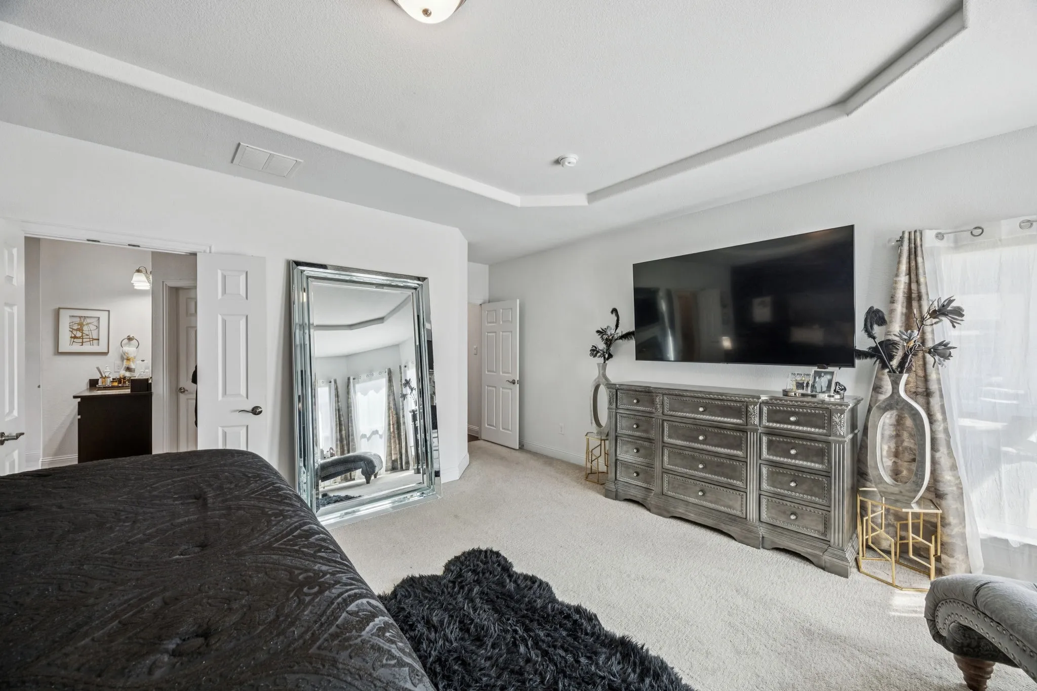 Bedroom with carpet floors and a tray ceiling
