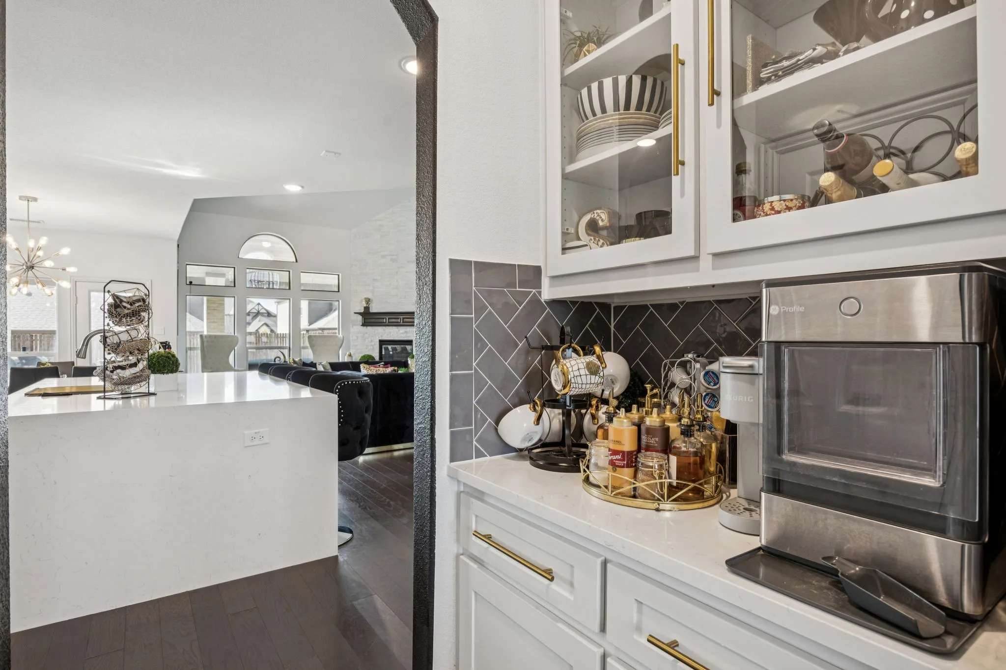 Bar area with light stone counters, dark wood finished floors, glass insert cabinets, white cabinetry, and recessed lighting