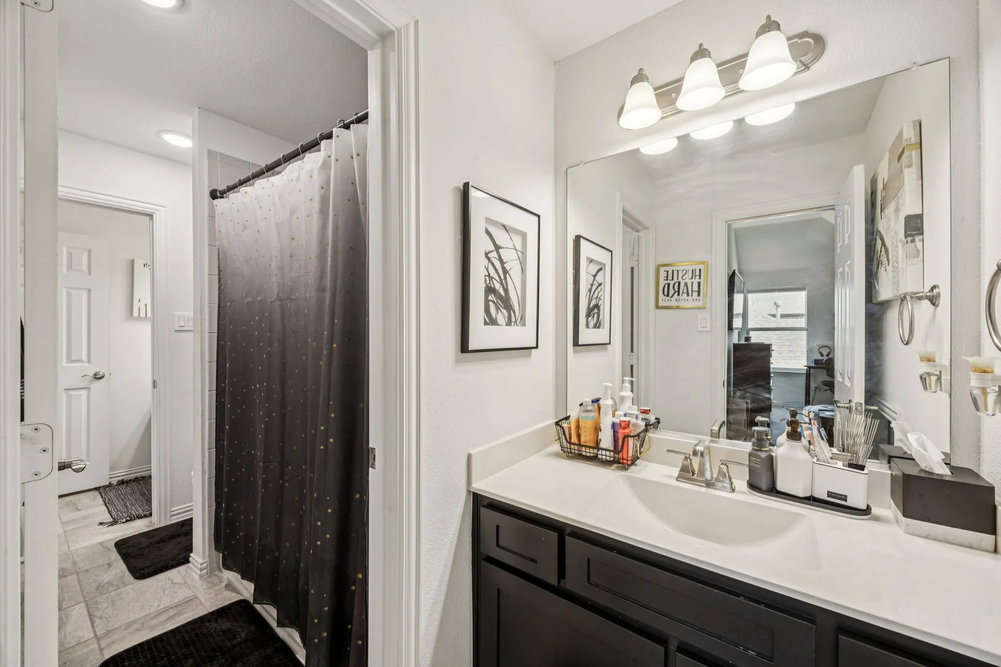Bathroom featuring vanity, light tile patterned floors, and a shower with shower curtain