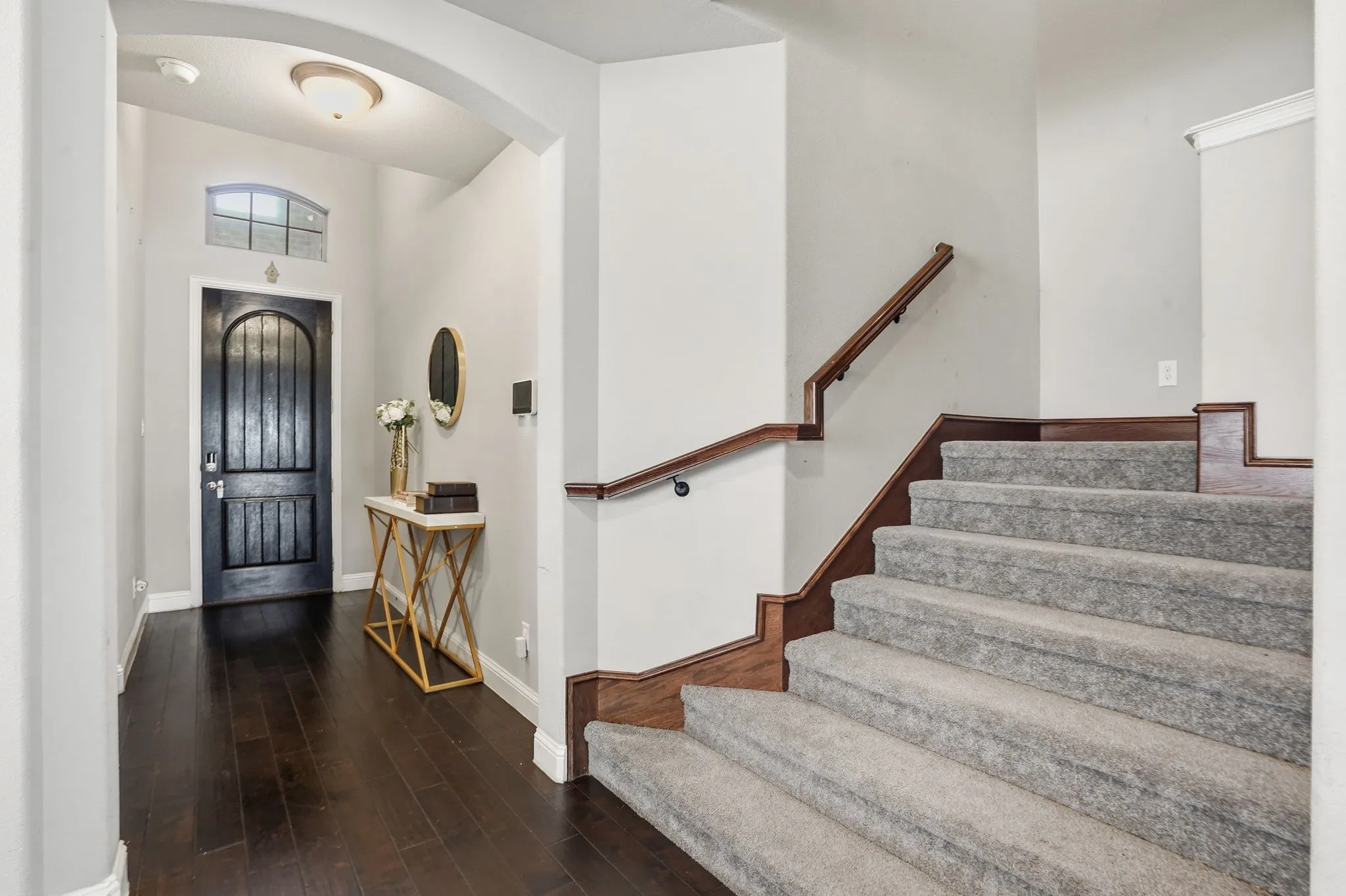 Entryway featuring dark wood-style floors and arched walkways