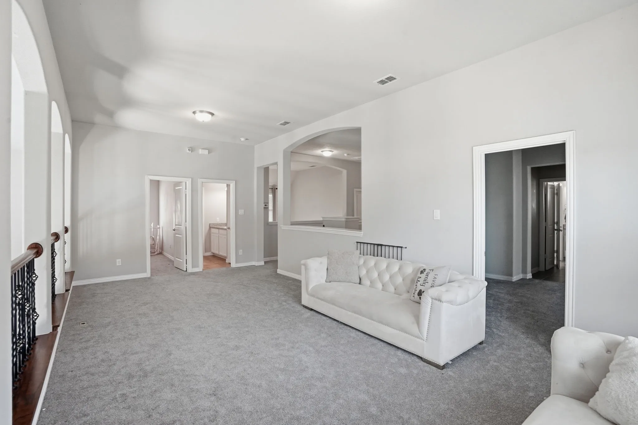 Unfurnished living room featuring carpet flooring and arched walkways