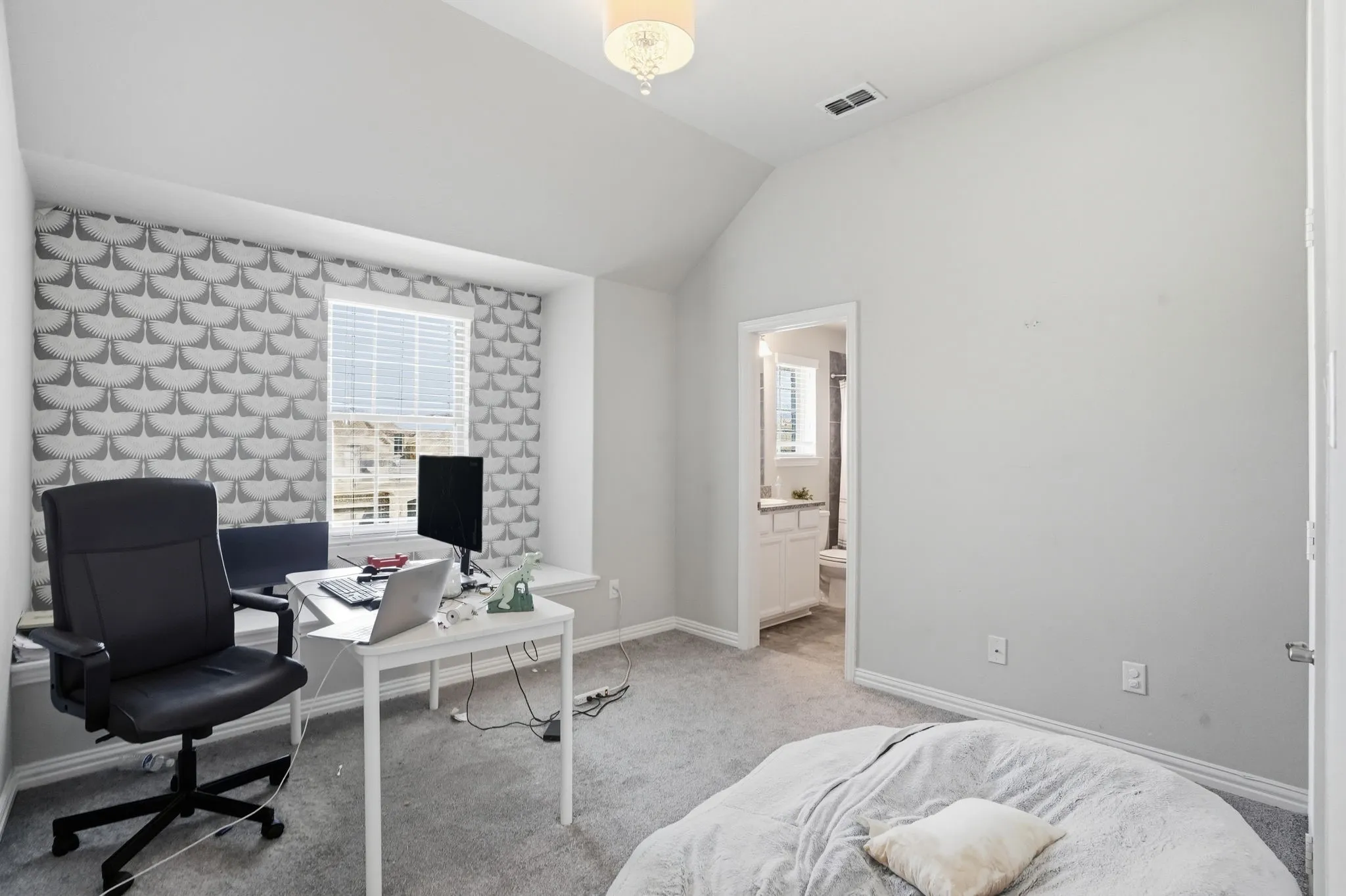 Carpeted office space featuring lofted ceiling and baseboards