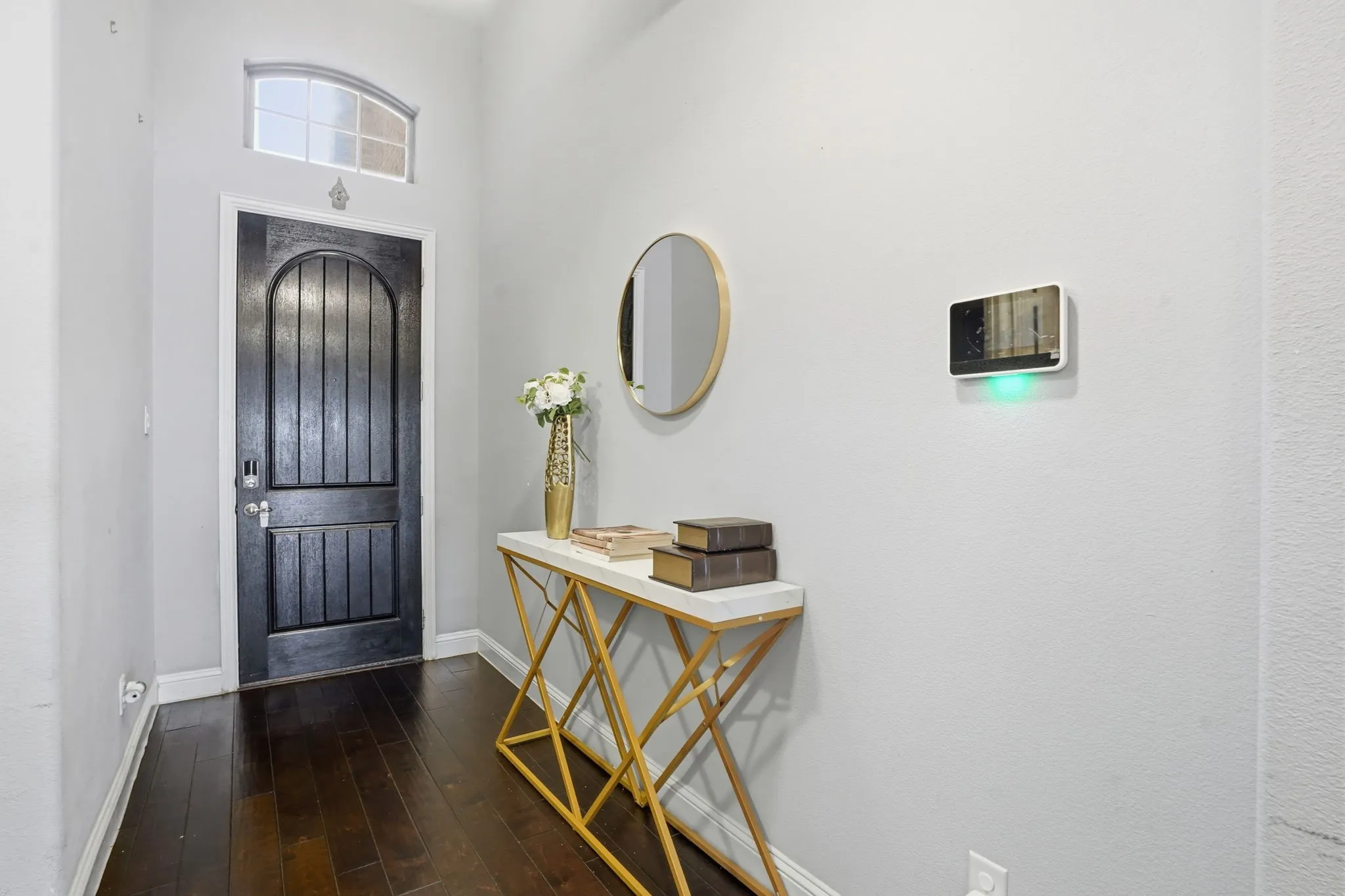 Foyer entrance with dark wood-style floors and a high ceiling