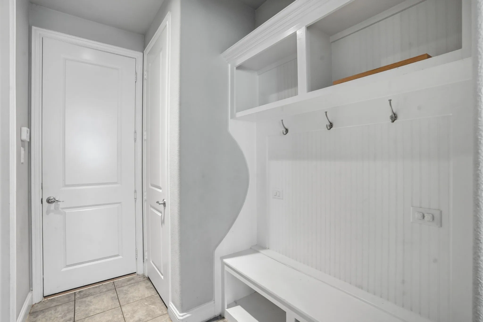 Mudroom with light tile patterned floors and baseboards