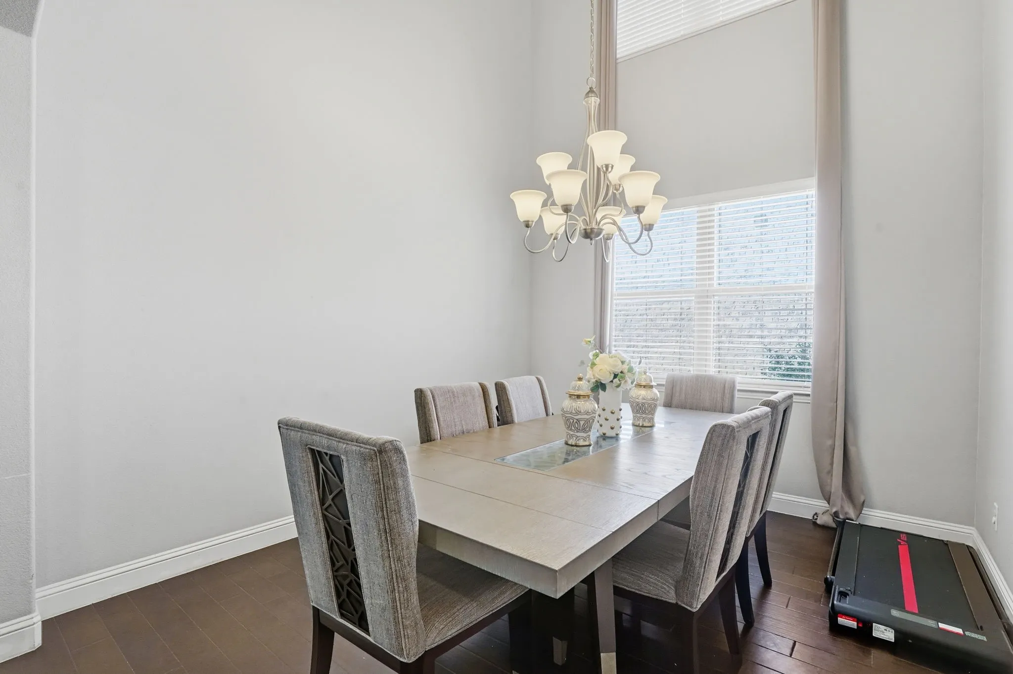 Dining area featuring dark wood-style floors and a chandelier