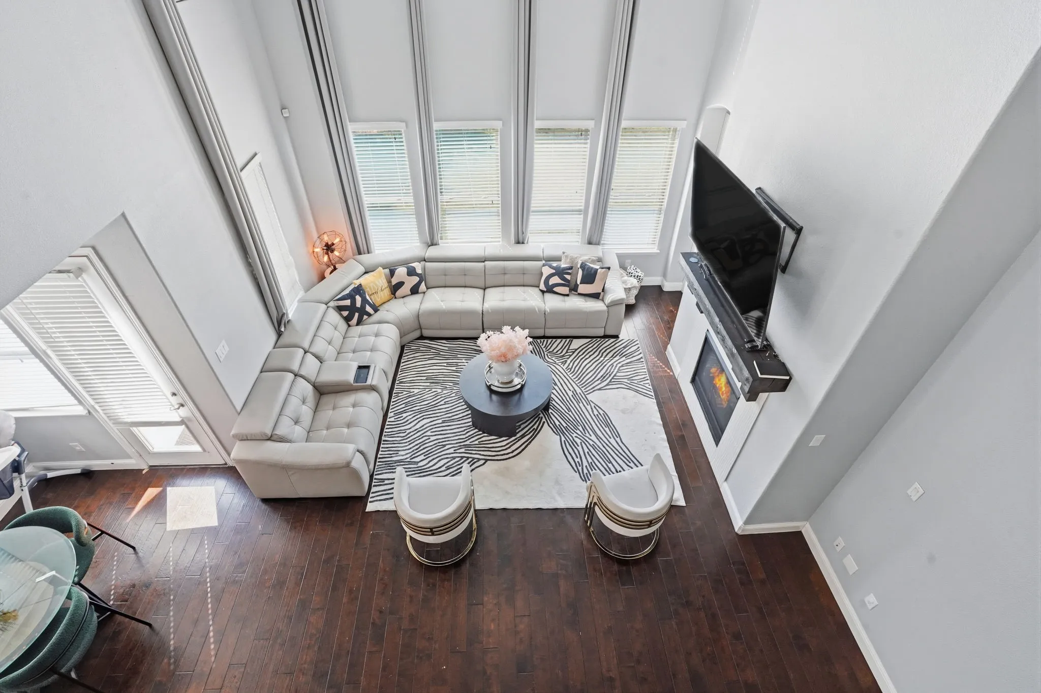 Sunken living room with dark wood-type flooring and a towering ceiling