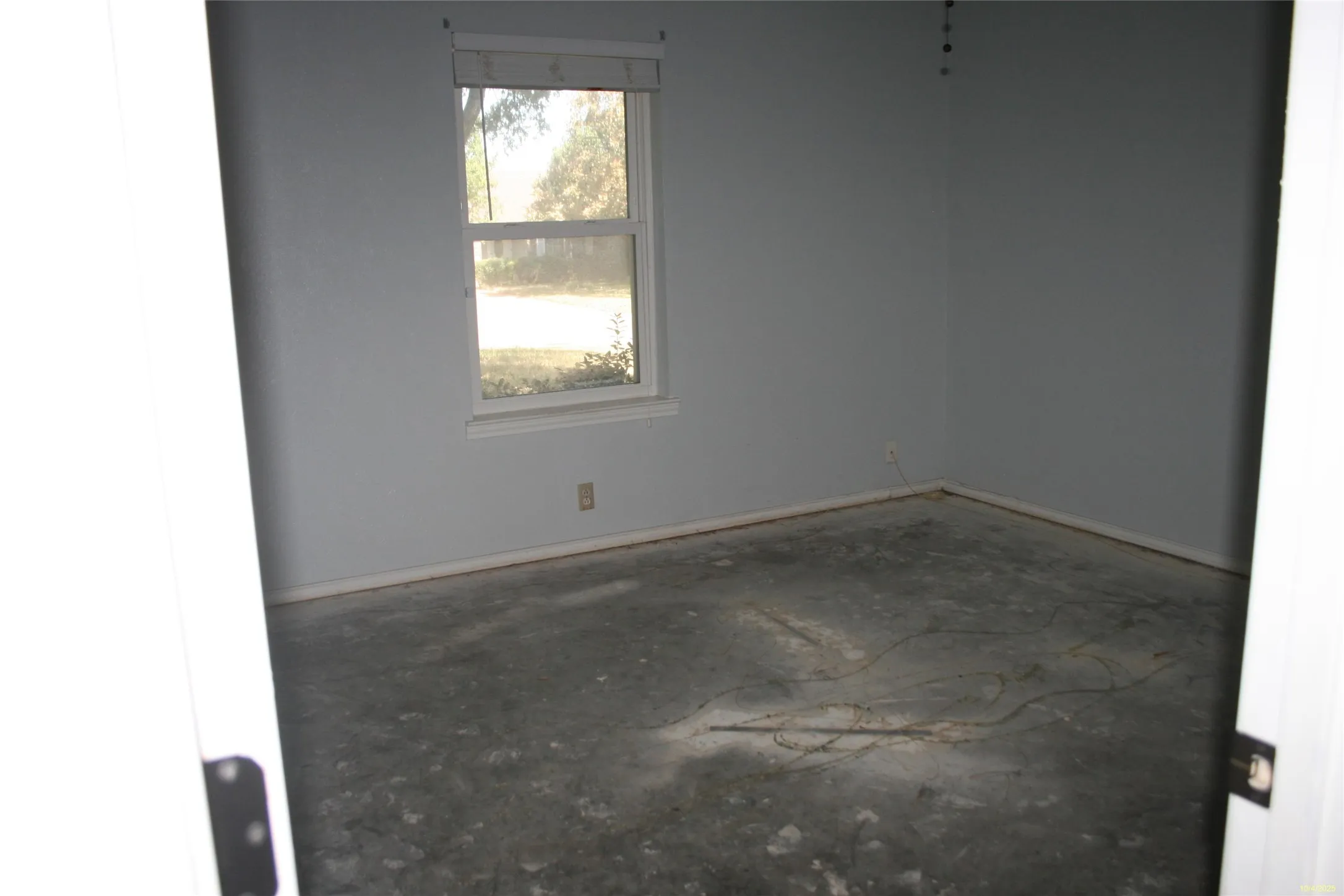 Spare room featuring baseboards and concrete floors