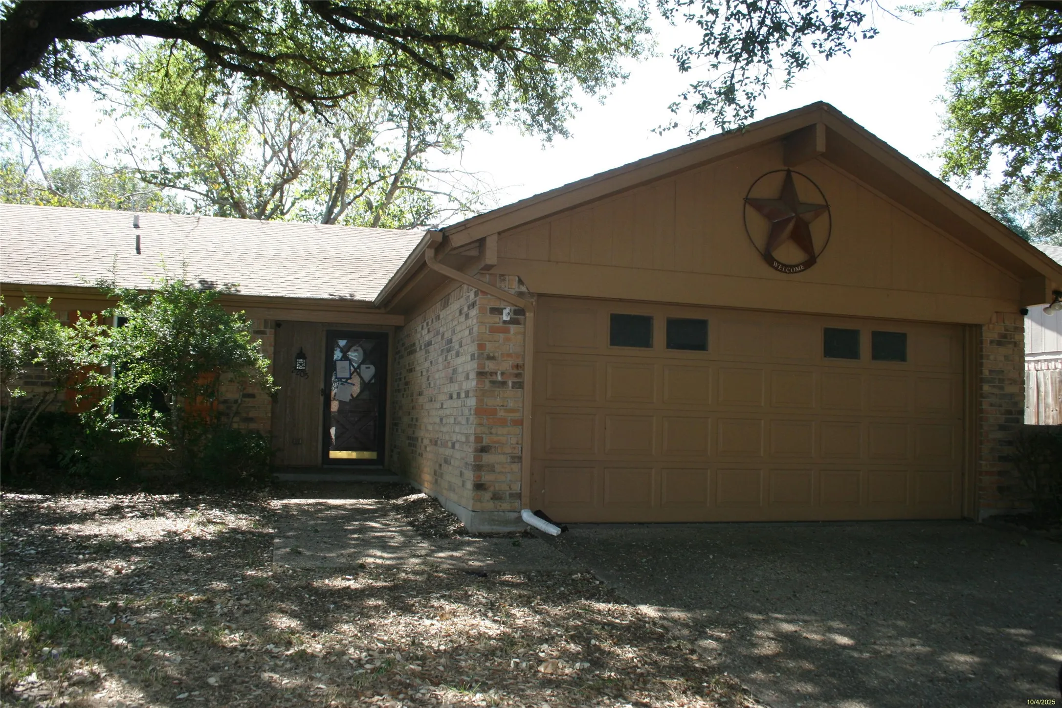 Ranch-style home featuring brick siding, an attached garage, and driveway