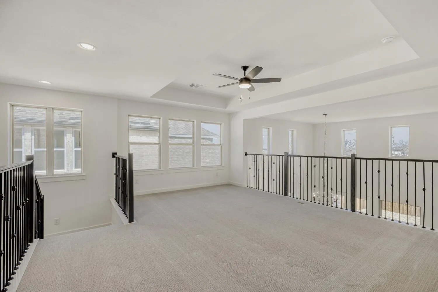 Spare room featuring a ceiling fan, carpet flooring, a tray ceiling, and recessed lighting