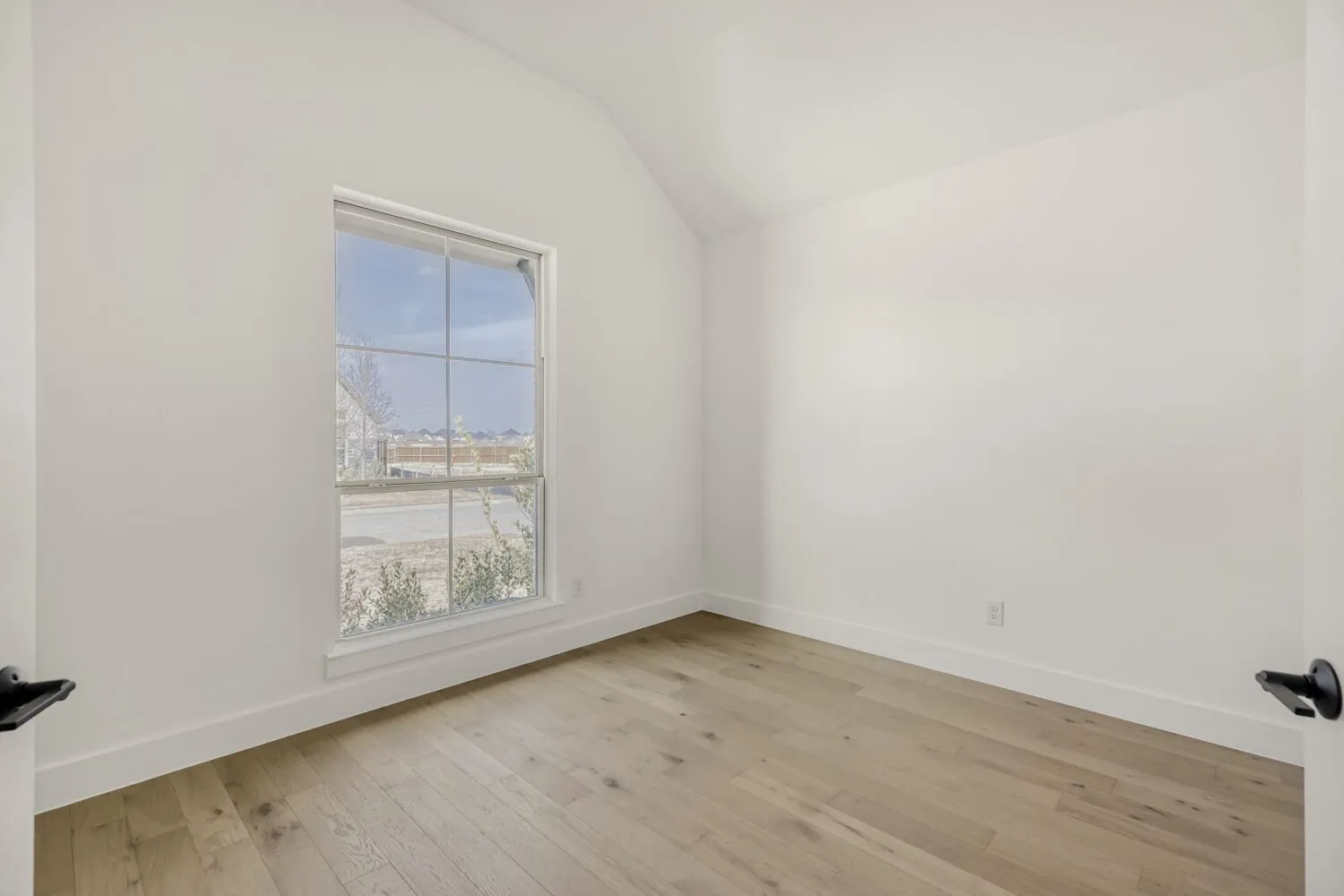Unfurnished room featuring lofted ceiling and light wood-style floors