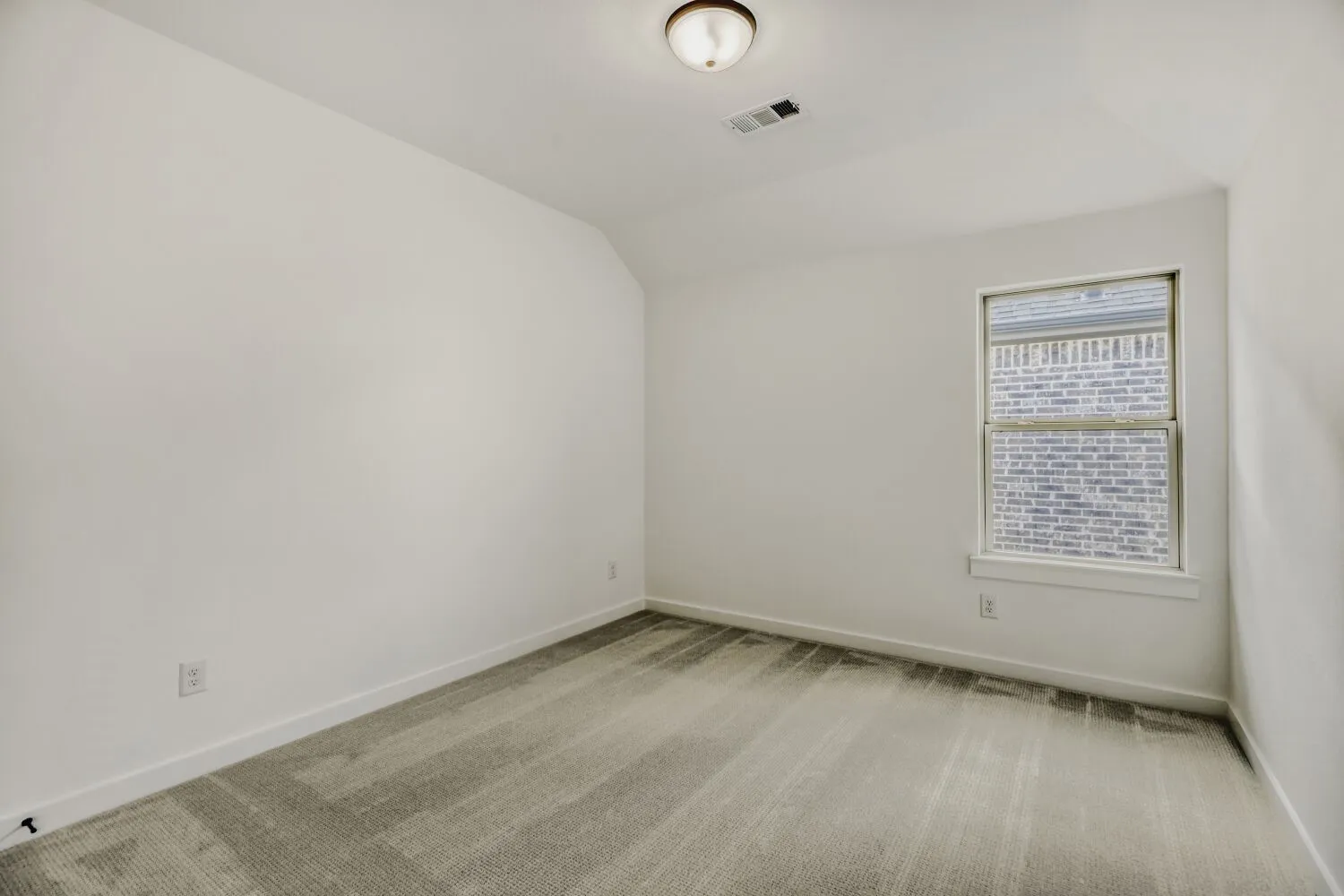 Spare room with light colored carpet and lofted ceiling