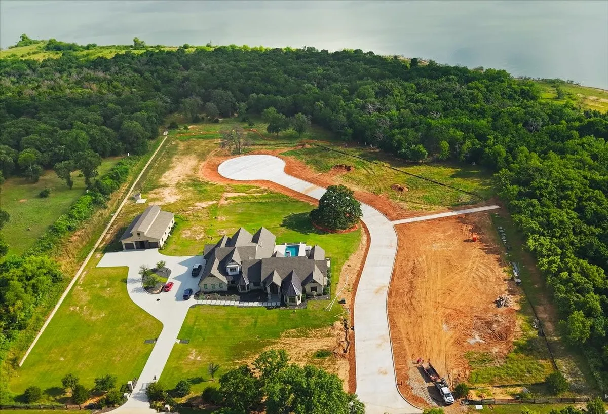 Expansive property featuring a substantial residence, detached multi-bay garage, and a private swimming pool