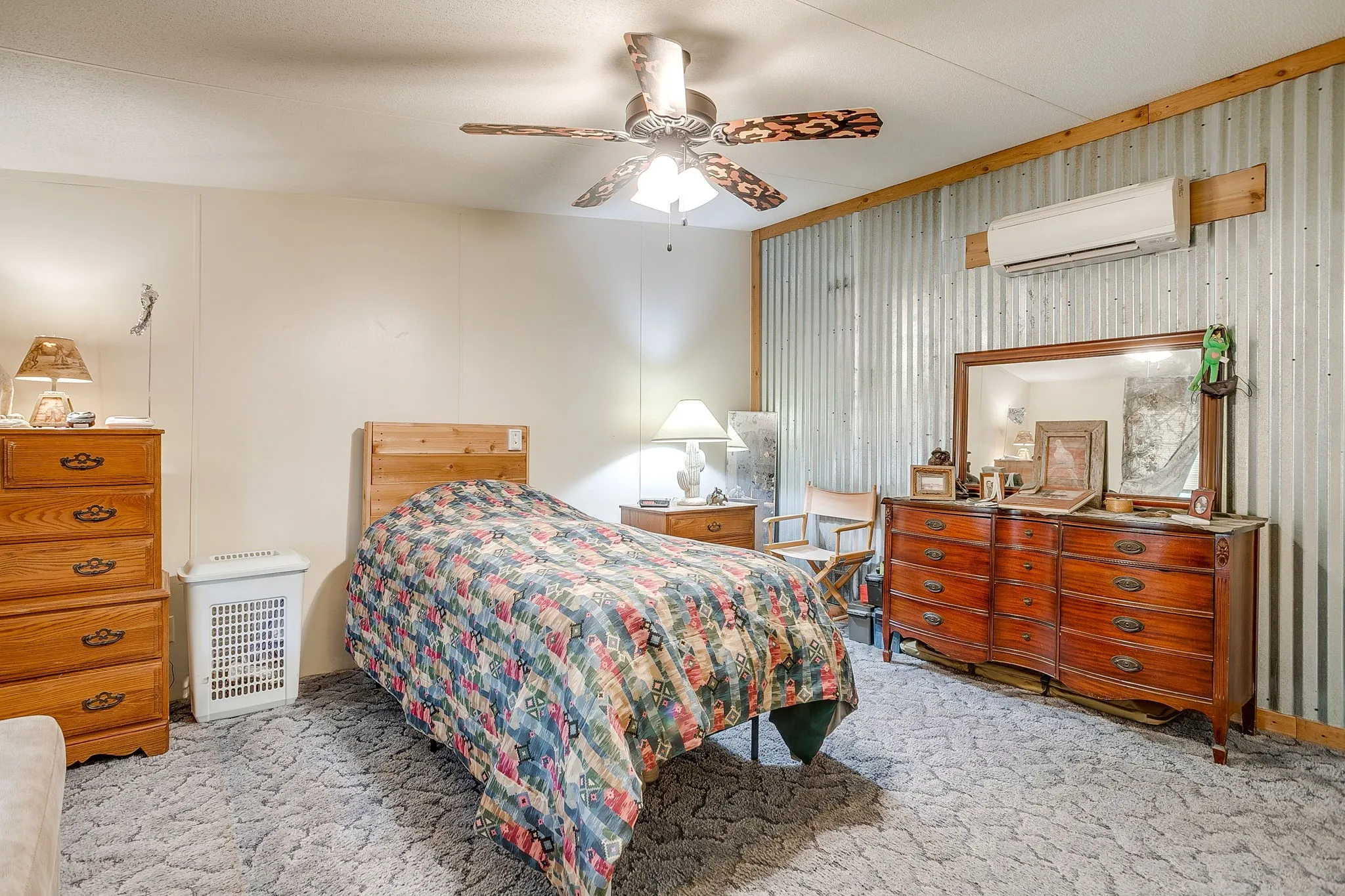 Bedroom featuring carpet flooring, a wall mounted AC, a ceiling fan, and radiator heating unit