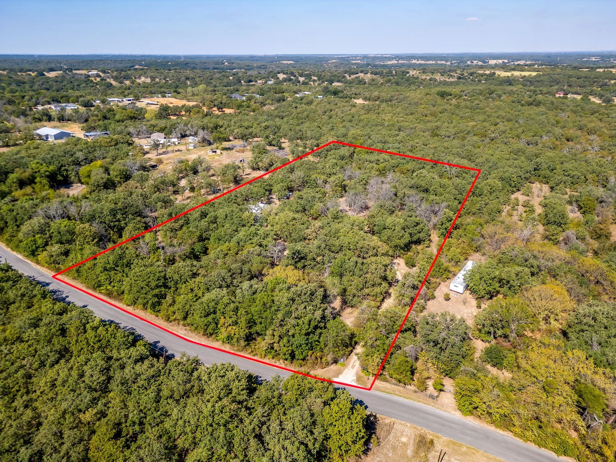 View of property location featuring property parcel outlined and a heavily wooded area