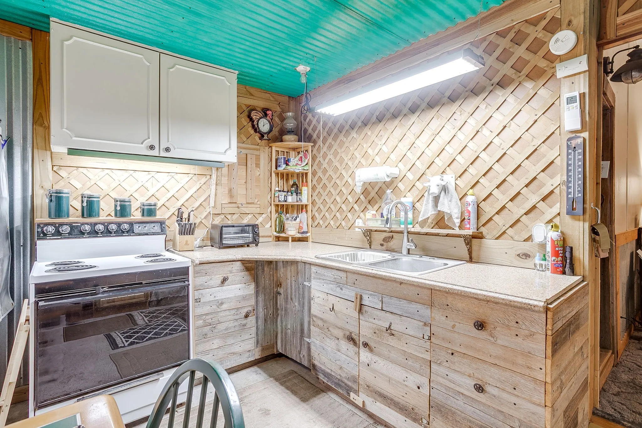 Kitchen featuring white range with electric stovetop, white cabinetry, and a sauna