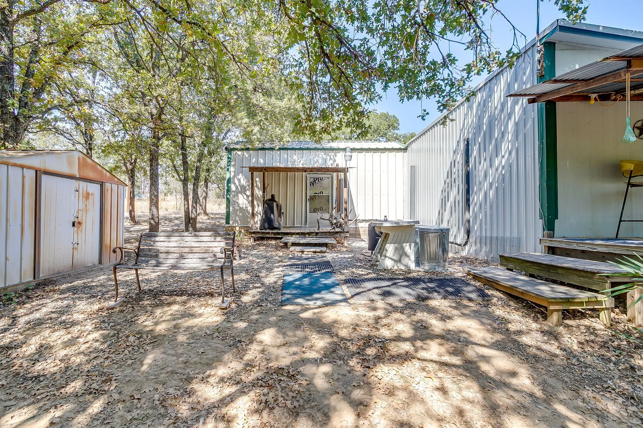 Back of property featuring a storage unit and a metal roof