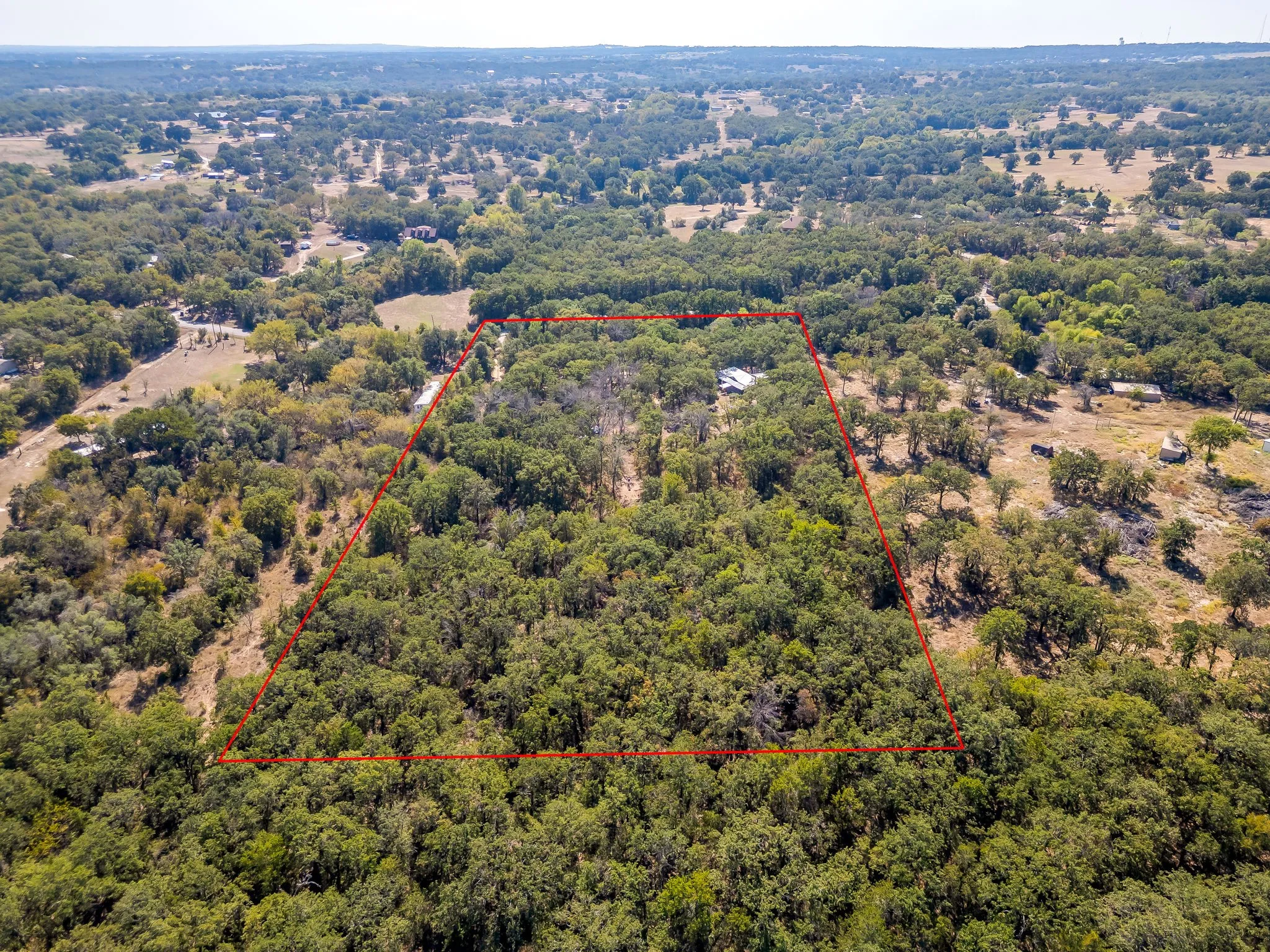 Aerial overview of property's location featuring property boundaries highlighted and a heavily wooded area from rear of property North looking toward front of property South