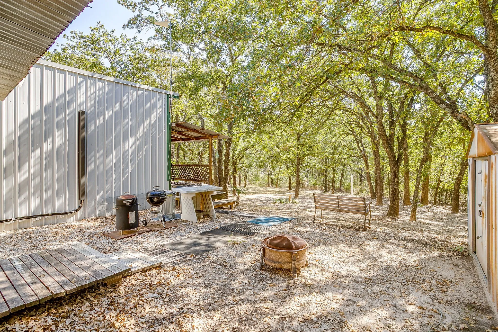 View of patio / terrace with a fire pit, a deck, and an outdoor structure