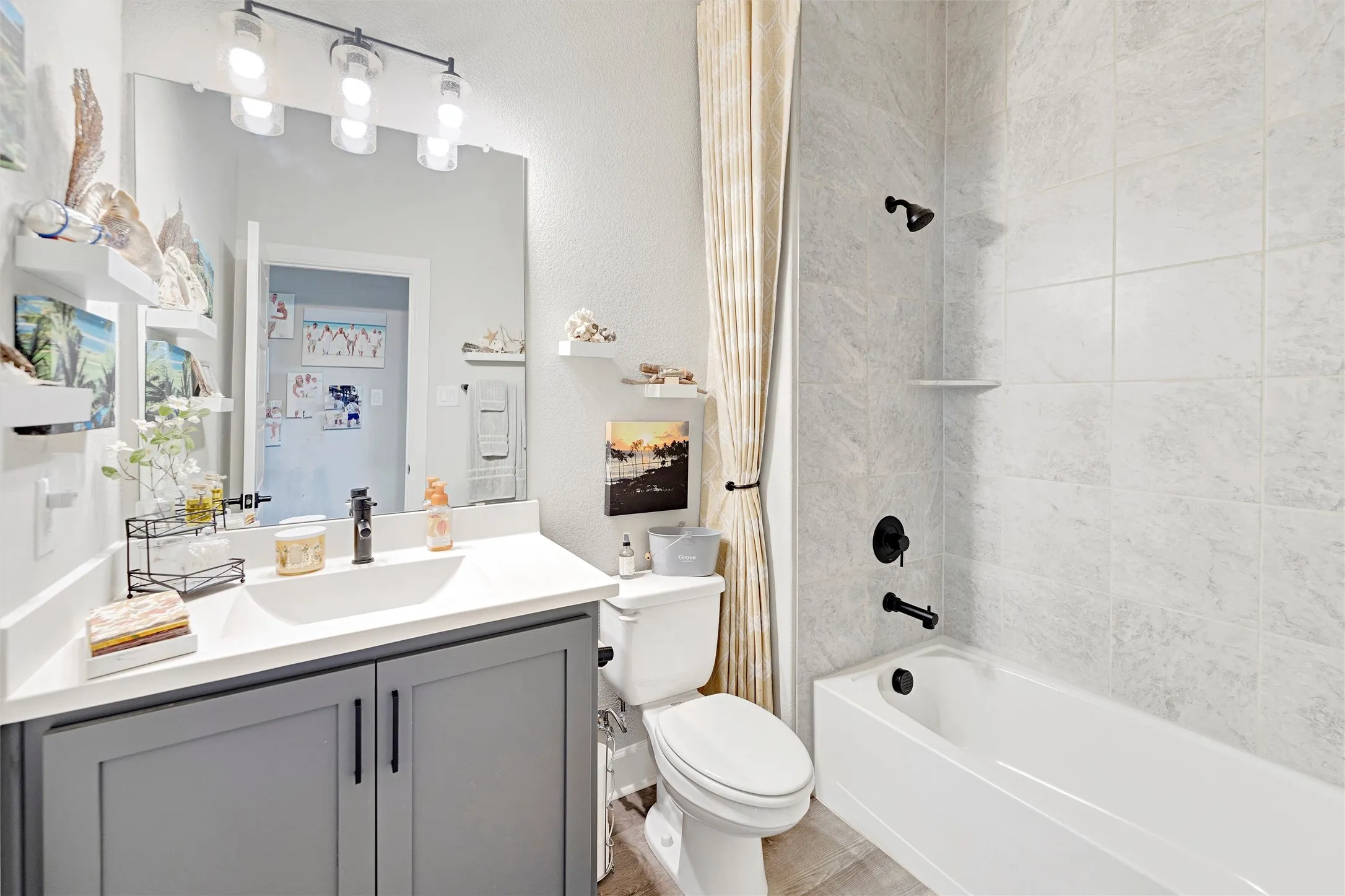 Bathroom featuring shower / tub combo with curtain, vanity, and a textured wall