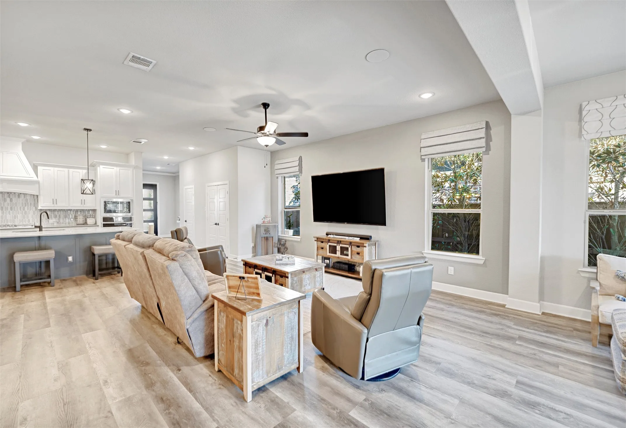 Living area featuring healthy amount of natural light, light wood-type flooring, a ceiling fan, and recessed lighting
