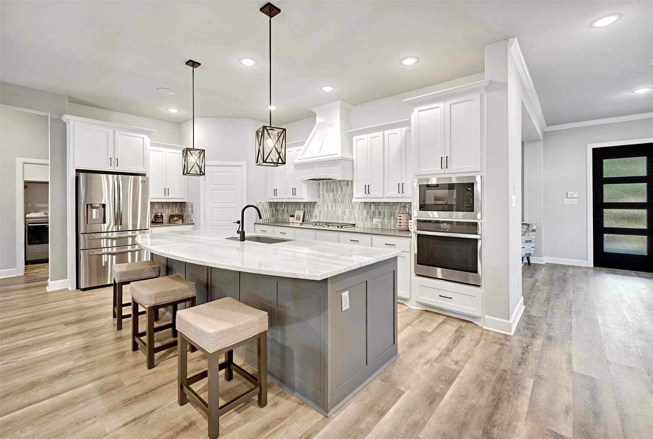 Kitchen featuring decorative backsplash, stainless steel appliances, gray cabinetry, a breakfast bar area, and recessed lighting