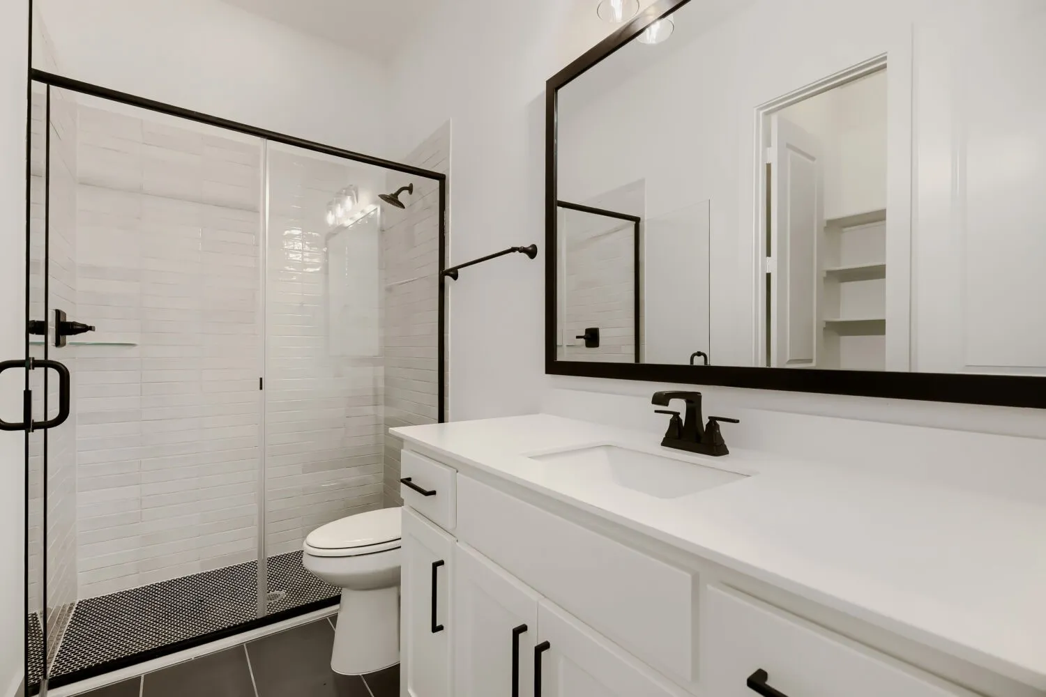 Bathroom featuring vanity, a shower stall, and dark tile patterned flooring