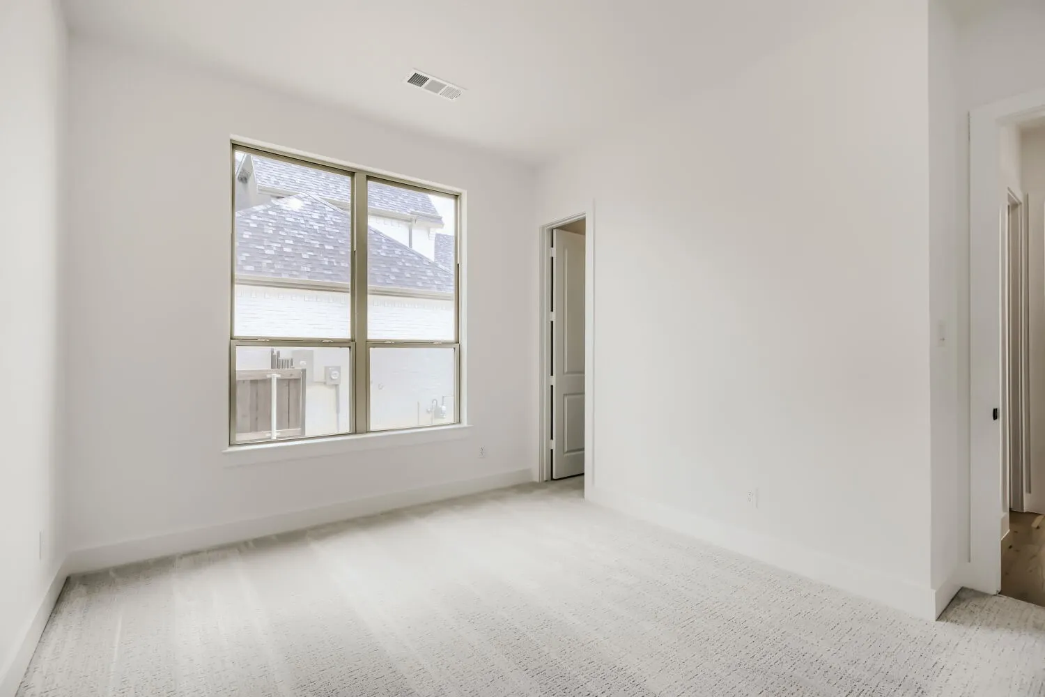 Spare room with light colored carpet and baseboards