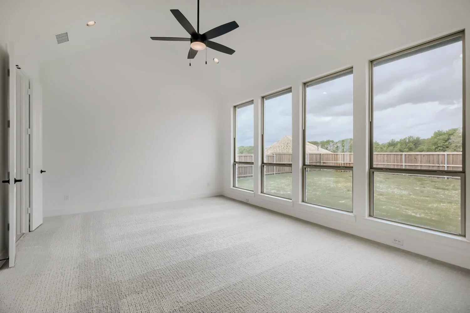 Empty room featuring light colored carpet, ceiling fan, recessed lighting, and lofted ceiling