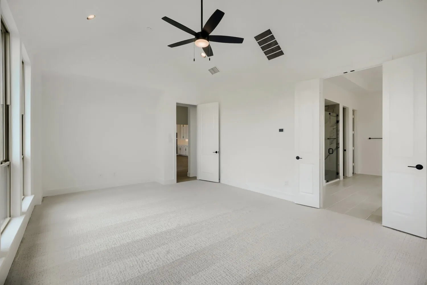 Unfurnished bedroom featuring light colored carpet, a ceiling fan, lofted ceiling, and recessed lighting