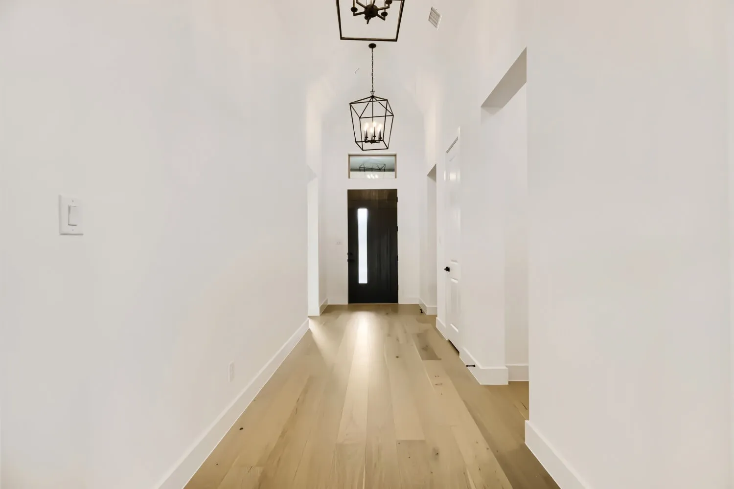 Entryway featuring a chandelier, wood finished floors, and a high ceiling
