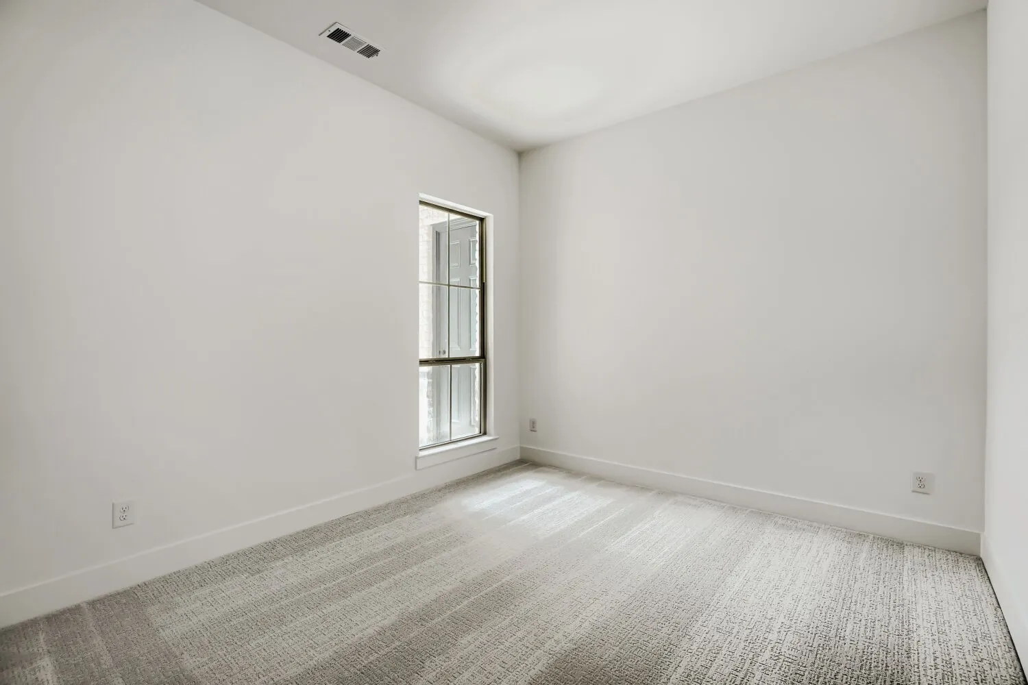 Unfurnished room featuring light carpet and baseboards