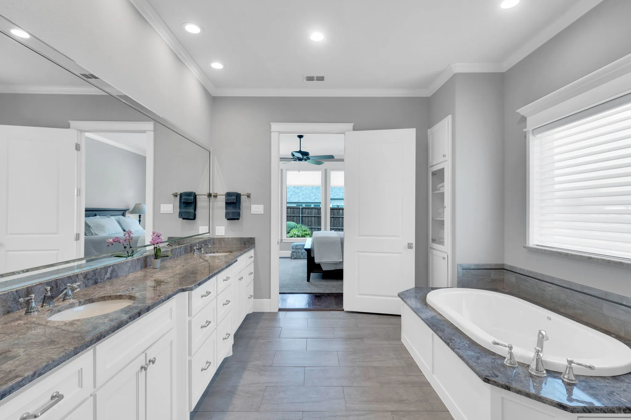 Ensuite bathroom with double vanity, ornamental molding, a ceiling fan, recessed lighting, and a bath